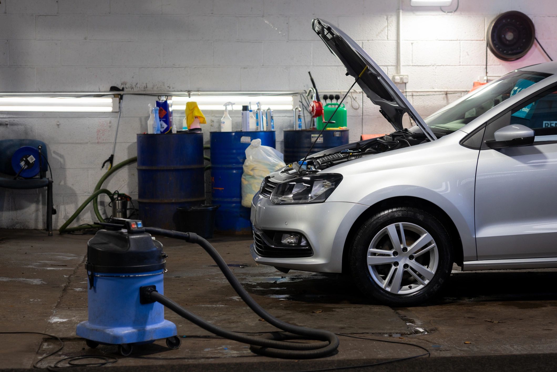 Car in a garage bay being serviced with tools nearby